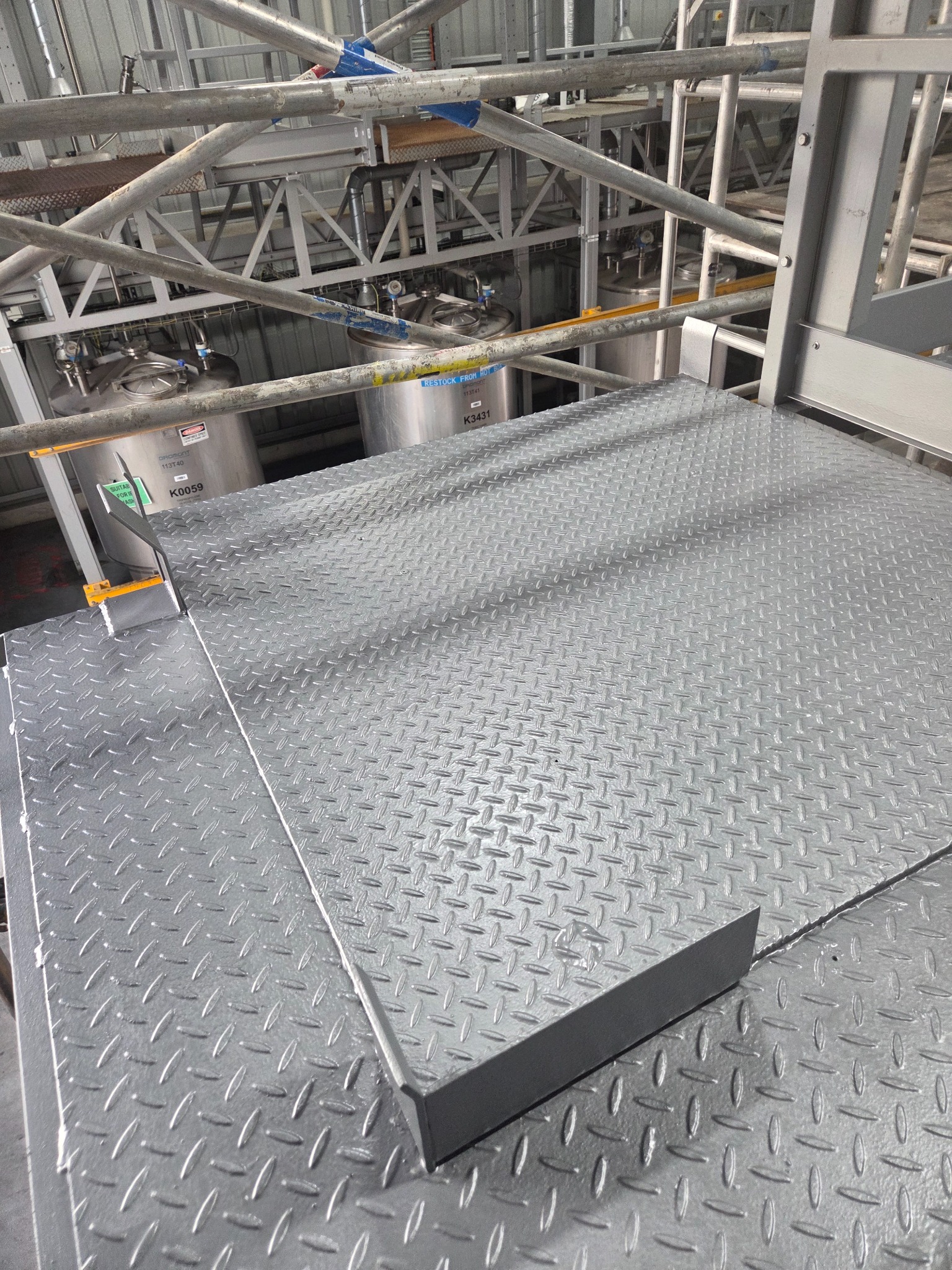 Completed grey epoxy and urethane coating on a chequer plate platform